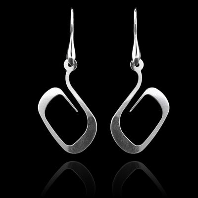 These sterling silver dangling earrings have thin hangs that curved into a round shape and depict a Haida Gwaii character.