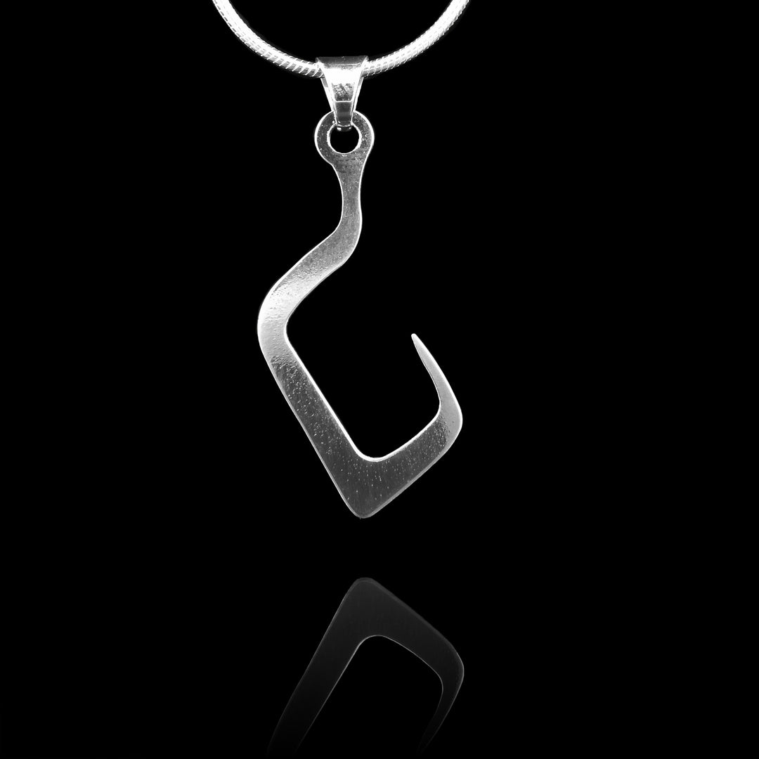 These sterling silver pendants are thin and curved in a zig-zag shape with the bottom curving into a hook shape. The curves of the hook are sharp. The piece represents a Haida Gwaii character.