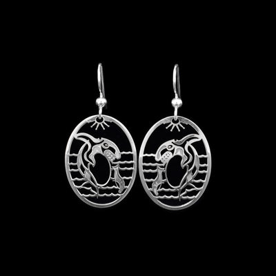 These Orca whale earrings are made from sterling silver and the hangs are oval shaped. There are cutout depictions of the Orca and waves that have been cast into the hangs.