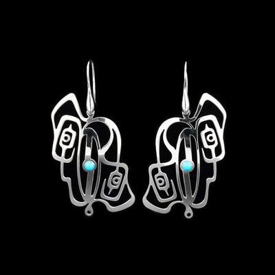 These Eagle and Raven turquoise earrings are made from sterling silver. There are cutout designs on the hangs that depict the Raven and the Eagle. The heads of the Legends are facing away from each other and there is a round, turquoise gem in the middle of the hangs.