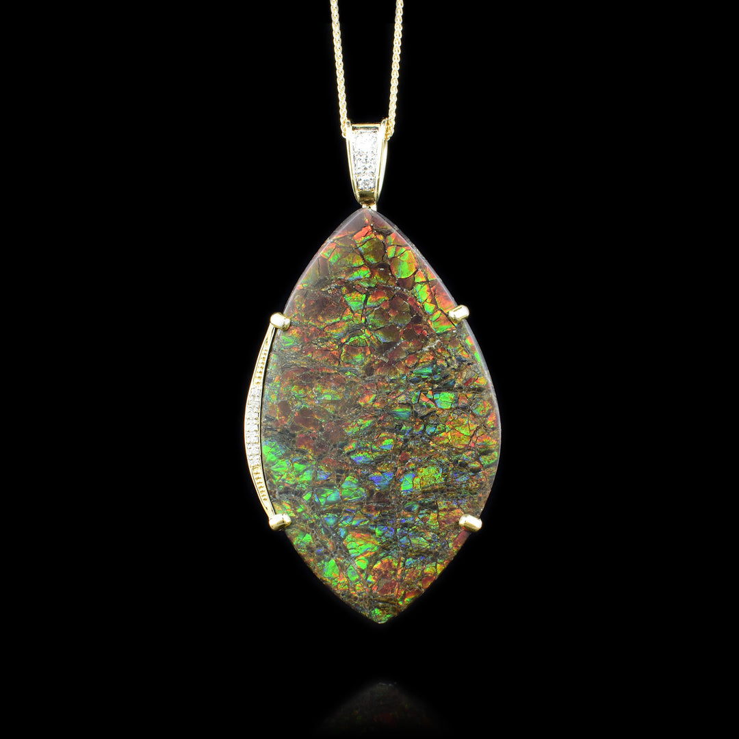Gold Ammolite Pendant a beautiful pieces of the oval ammolite is framed with gold with diamonds imbedded in the gold.