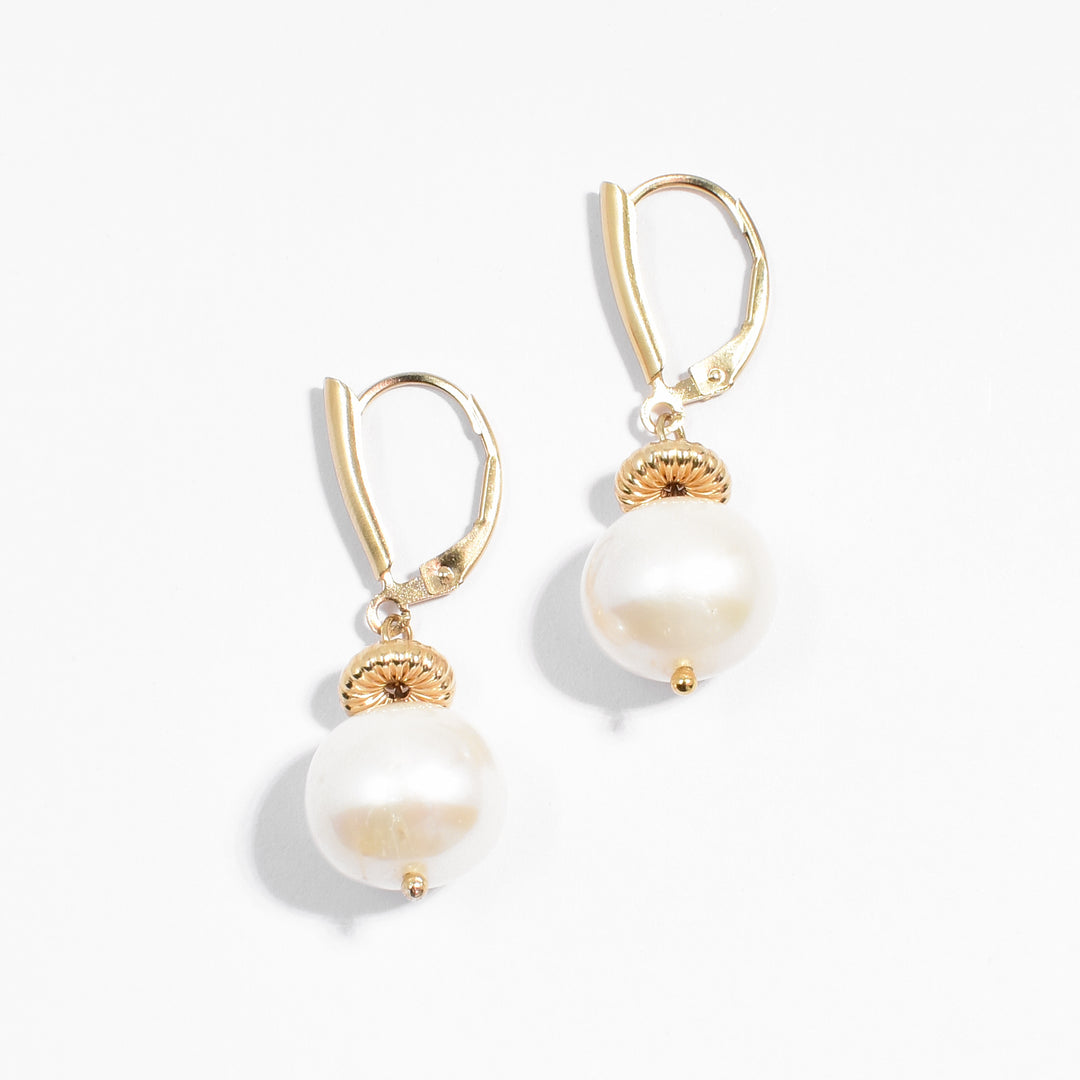 Gold-fill lever-back dangle earrings featuring two round, white freshwater pearls.