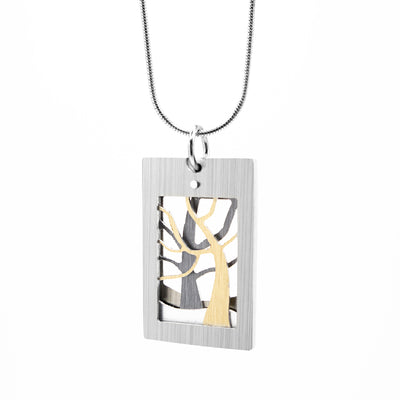 Flat, rectangular pendant with silver-colour frame. Two trees with naked branches next to each other inside. Gold-colour tree in forefront.