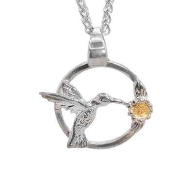 Round, sterling silver cut out hummingbird pendant, 22K gold nuggets in flower. By Tom Gregorczyk.