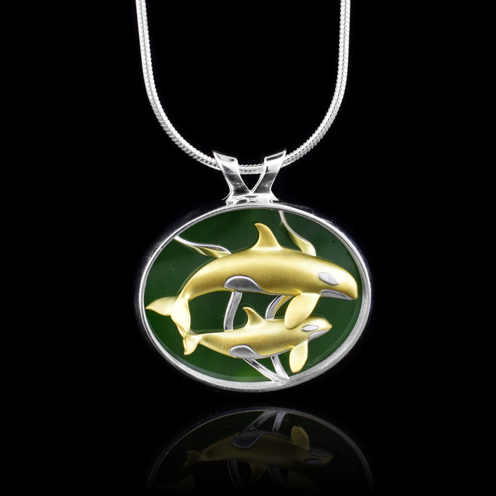 Gold Orca Pod BC Jade Pendant, Surrounded by the sterling silver frame sit high quality AA Jade. on top of the jade are two 10k gold orca whales representing a pod of orcas. 
