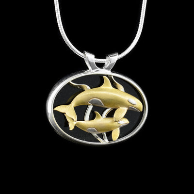 Sterling silver, 14K white gold and 14K yellow gold pendant featuring an orca mother and her calf swimming among kelp. Handcrafted by Dennis Kangasniemi.