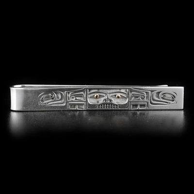 Tie clip featuring Chilkat bentwood box, 18K gold in eyes on front of box. Laser-carved design. By Tahltan artist Grant Pauls.