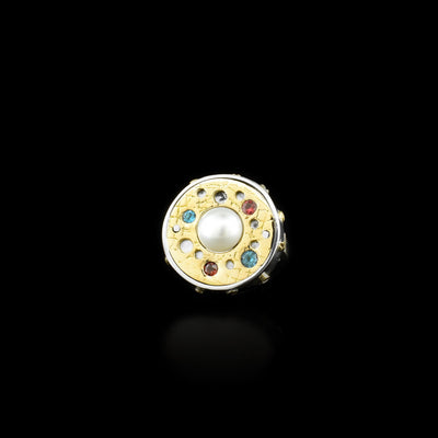 Sterling silver and 14K yellow gold gemstone orbit ring with white mabe pearl in center. Made with mother of pearl, garnet and blue topaz. By Ivan Dobren.