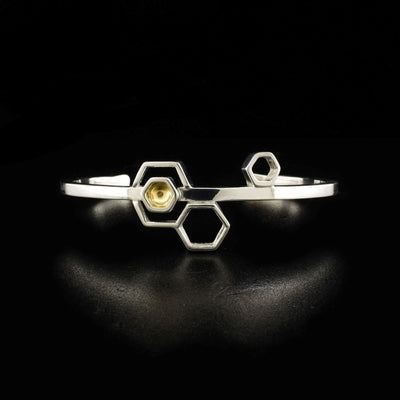 Sterling silver wire cuff bracelet with abstract honeycomb design on front. One hexagon has 14K gold inside.