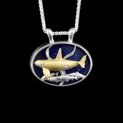 Features a gold and silver orca swimming underwater among kelp, with salmon below. Lapis background. Silver frame and bail. Made of sterling silver and 14K yellow gold.