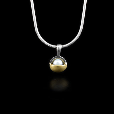Sterling silver pendant with white freshwater pearl set in bowl shape. Pearl is half covered by brushed 14K yellow gold on bottom.
