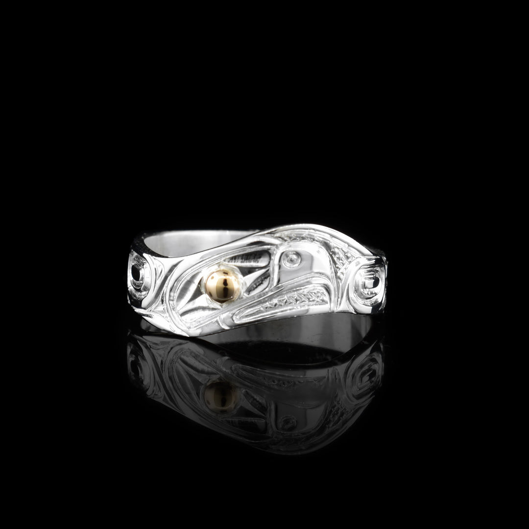 This sterling silver wavy band has been hand-carved with the legend of the eagle. The eye of the eagle is made with 14k gold.