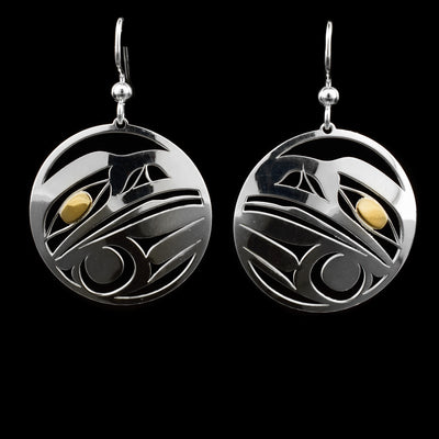 These dangling Raven earrings are made from sterling silver and 14K gold with circle shaped hangs. There are cutouts depicting Raven made into the surface of the hangs and the eyes are made from gold.
