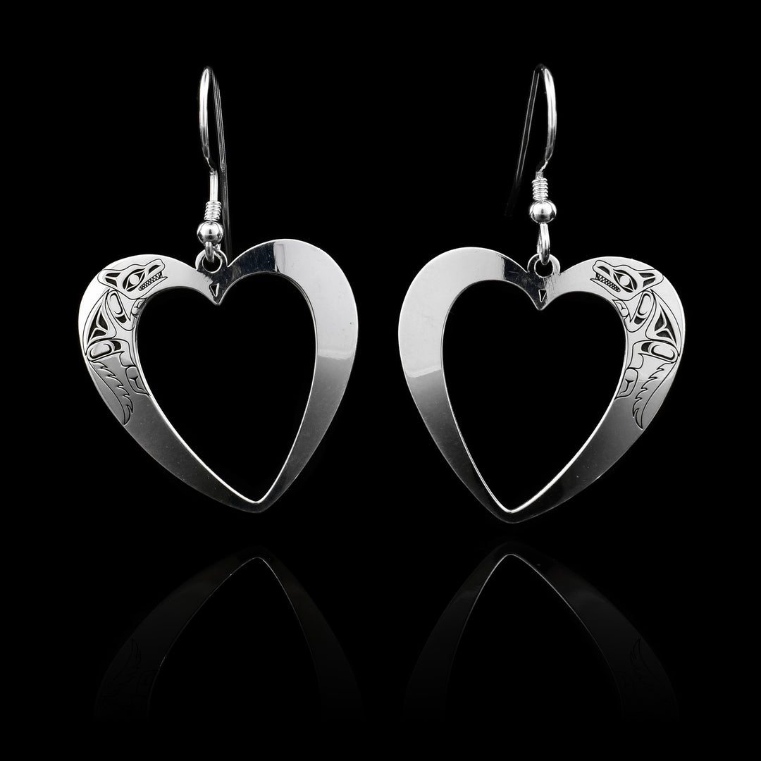 These heart dangle earrings are made from sterling silver. They have heart shaped hangs with large heart shaped cutouts in the middle of them. There is a depiction of the Wolf that have been cutout from the surface of the hangs.