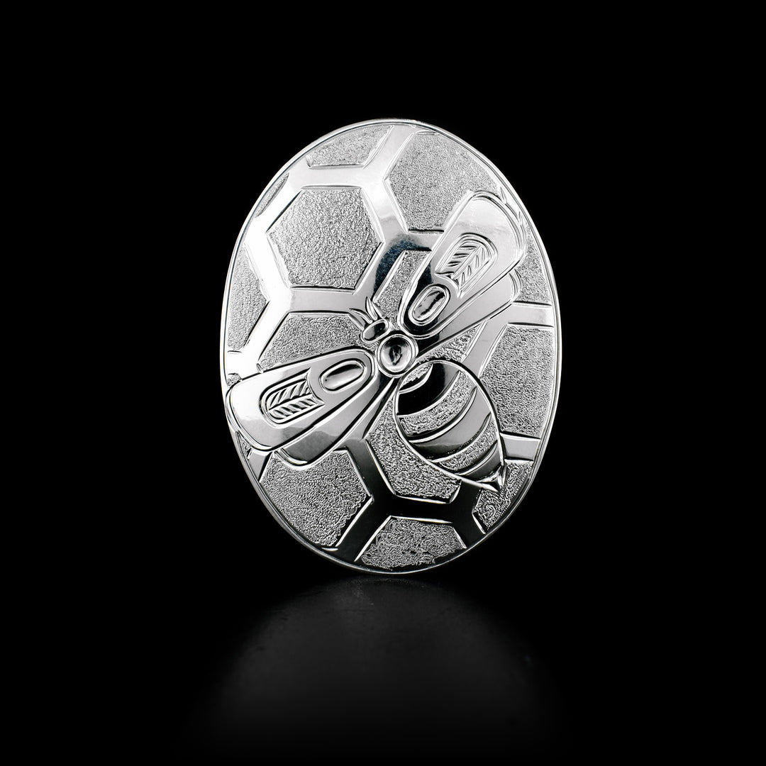 This sterling silver Bee brooch is oval in shape, and has the Bee carved on it. In the background of the Bee, there is a textured honeycomb pattern.