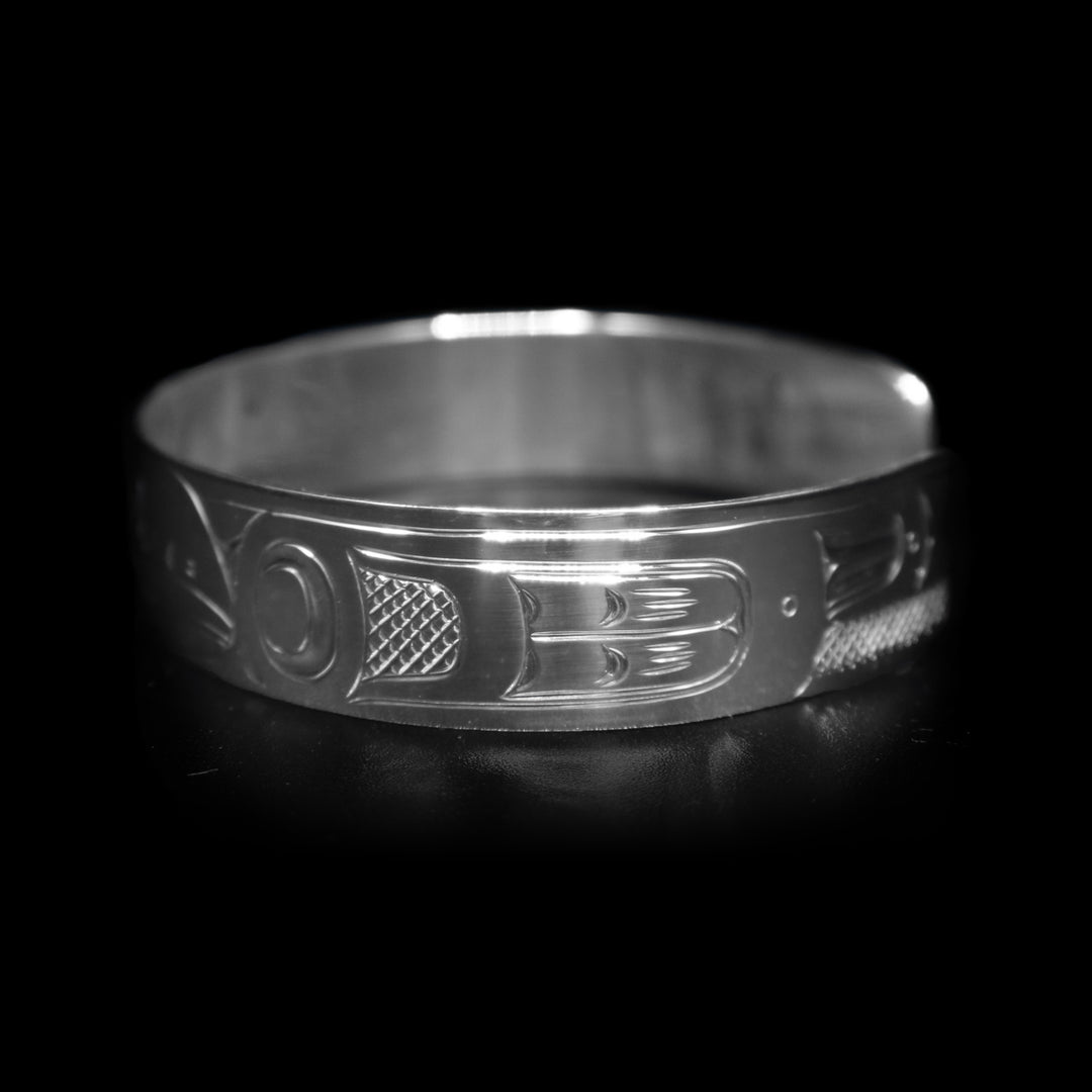 This sterling silver cuff bracelet has a single band with a gap in the back. There is a depiction of the Raven that has been beautifully carved into the surface of the band.