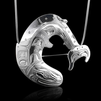 This Salmon fish pendant is made form sterling silver and is shaped like and has carvings on the surface of the piece depicting the Salmon.