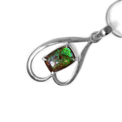 Rectangular piece of ammolite set in pendant, shines different colours depending on how you look at it. A sterling silver frame creates an uneven upside-down heart. Pendant is made of ammolite and sterling silver.