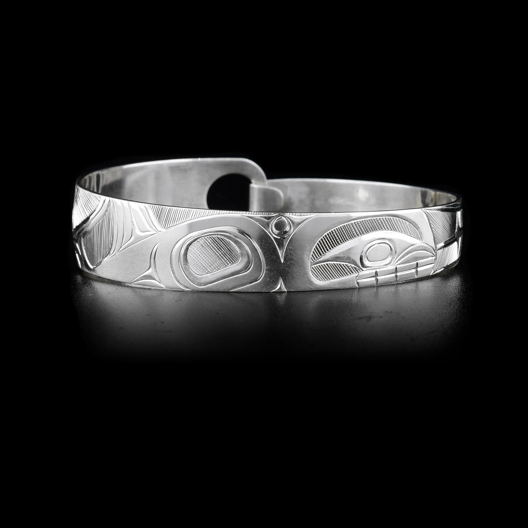 This sterling silver, tapered Orca bracelet has a depiction of the Orca carved into it.