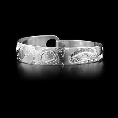 This sterling silver, tapered clasp bracelet has a depiction of the Orca carved into it.