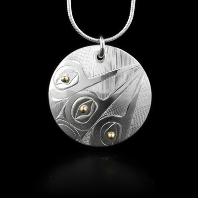 This sterling silver Hummingbird pendant is circle shaped has carvings of three depictions of the Hummingbird on it. The eyes of the Hummingbirds are made from 14K gold beads.