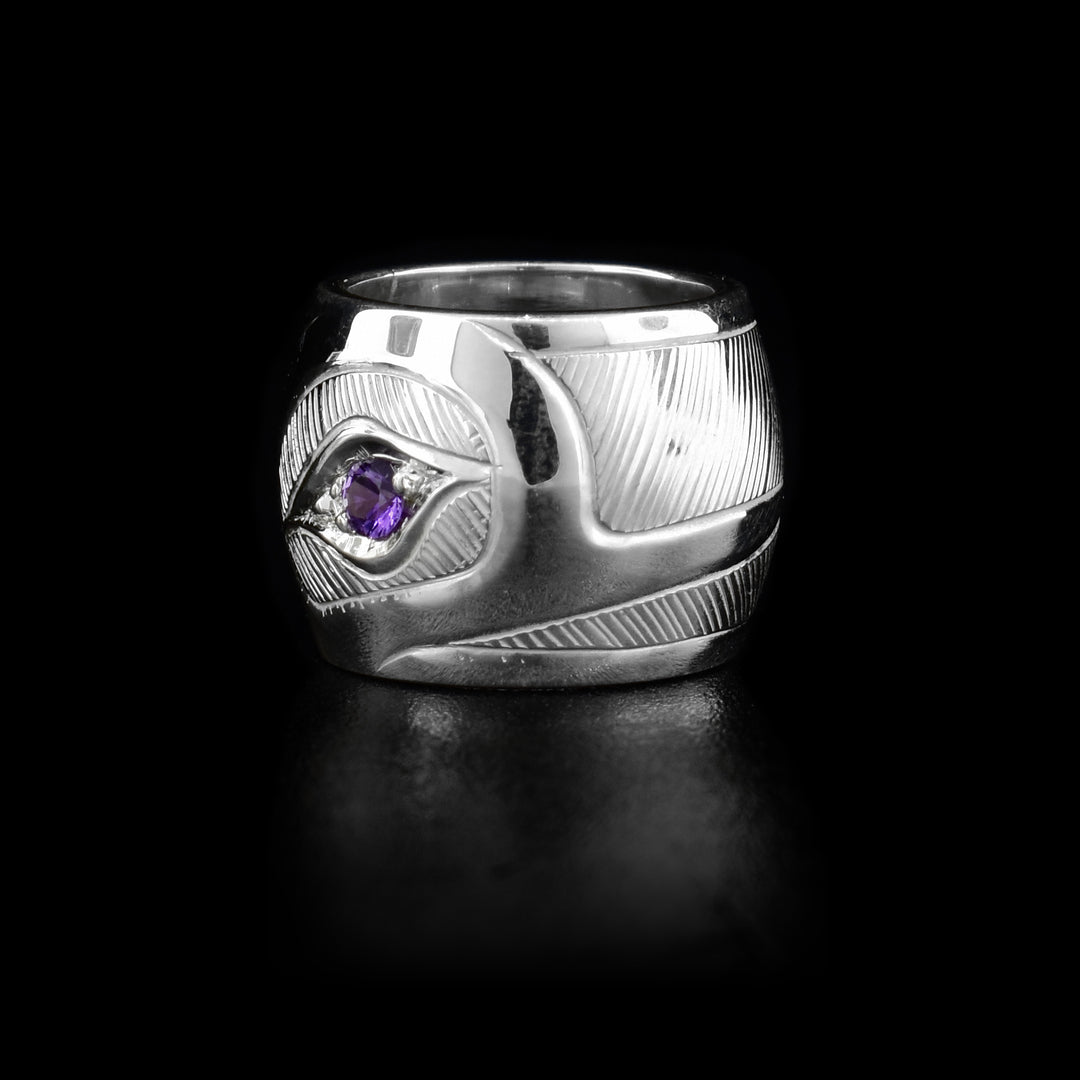This spirit bead is made from sterling silver and has a depiction of the Hummingbird carved into it. There is an amethyst gemstone embedded in the eye of the Hummingbird.