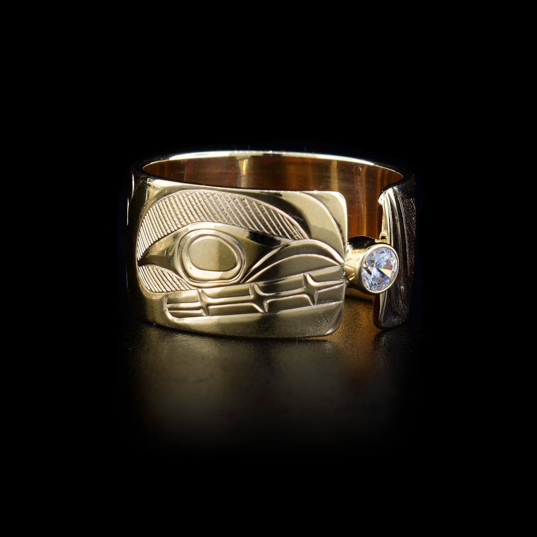This 14K gold, split diamond ring has a wide band with a depiction of the Orca carved into it. There is a diamond gem in the middle of the split.