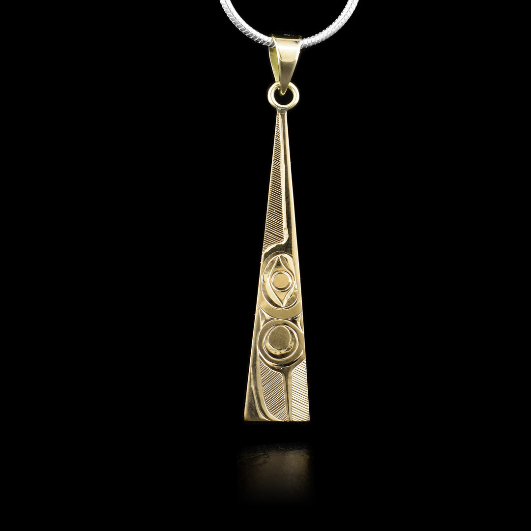 This 14K gold pendant is shaped like a long thin triangle. There is a depiction of the Hummingbird carved into it.