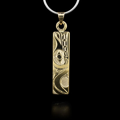 This 14K gold pendant is thin and rectangular and has carvings that depict the Wolf on it.