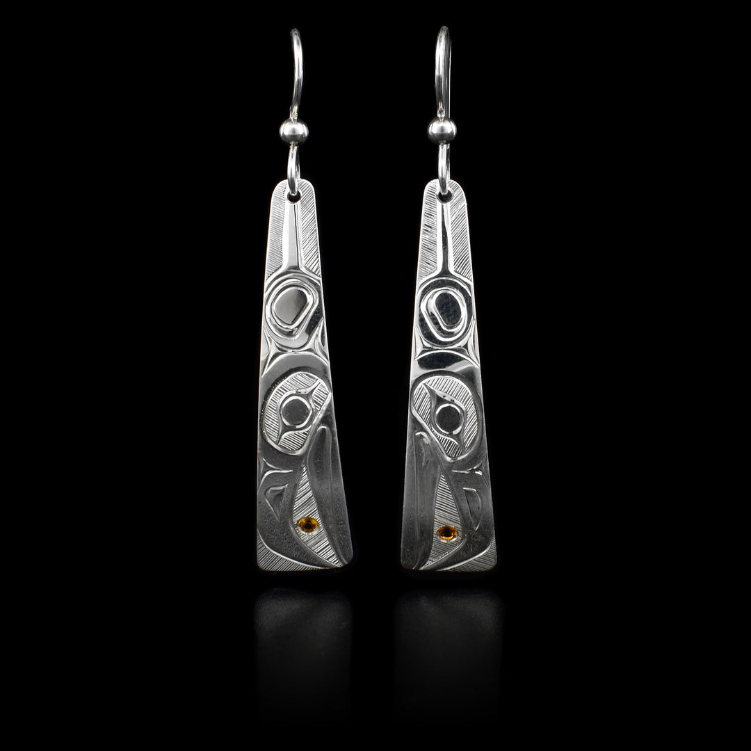 These long Raven earrings are made out of sterling silver and have a long triangular shape. They depict the wing and the face of the Raven. The Raven is holding the Sun in its beak, the Sun is represented with a piece of citrine embedded into the earrings.