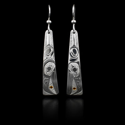 These earrings are made out of sterling silver and have a long triangular shape. They depict the wing and the face of the Raven. The Raven is holding the Sun in its beak, the Sun is represented with a piece of citrine embedded into the earrings.