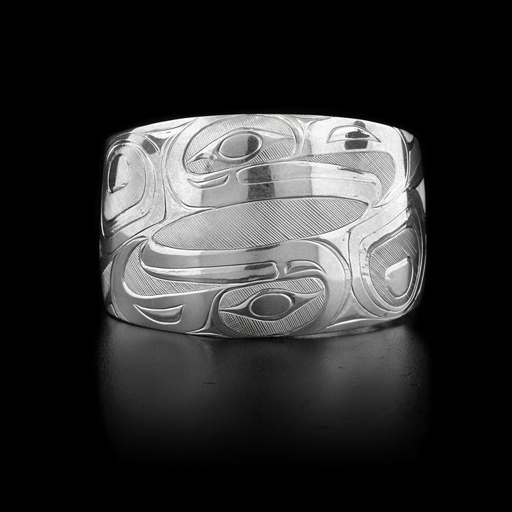 This sterling silver Eagle bracelet is a cuff and wider at the top than at the bottom. It is chunky and has two intricate depictions of the Eagle carved into it.