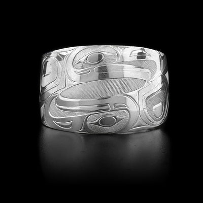 This sterling silver cuff bracelet is wider at the top then at the bottom. It is chunky and has two intricate depictions of the Eagle carved into it.