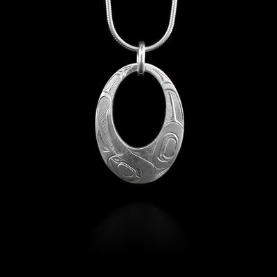 This sterling silver pendant is oval shaped with a large oval cutout in the center. It is engraved to depict the Eagle.