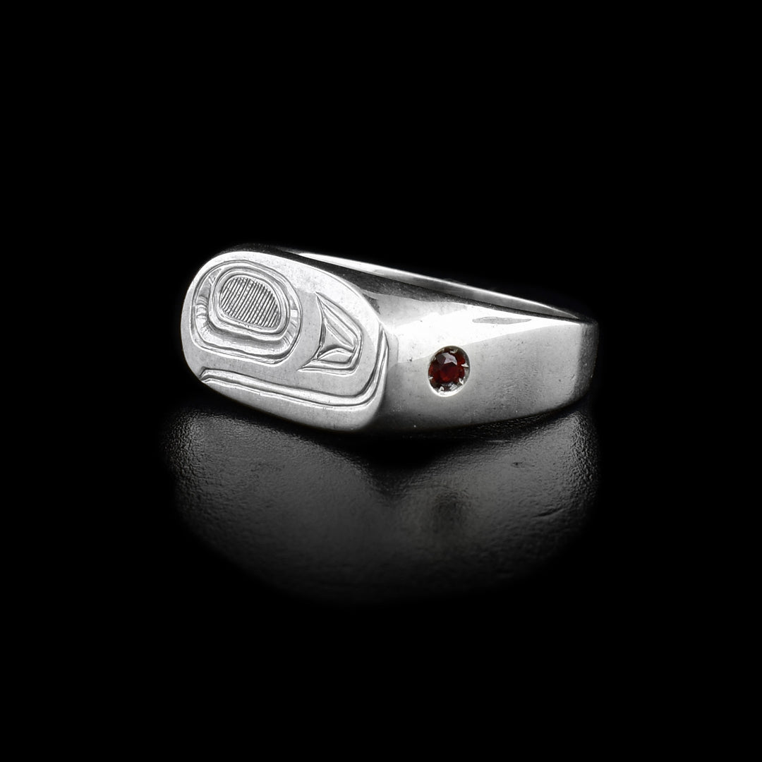 This sterling silver signet ring has an oval signet with the Salmon carved into it. On both sides of the signet are embedded garnet gems.