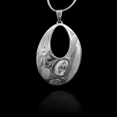 This sterling silver pendant is oval shaoped and has an oval cutout near the top. The depiction of the Hummingbird is carved on the surface. 