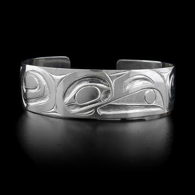 This stelring silver cuff bracelet is wide and has deep carvings depicting the Raven on its surface.