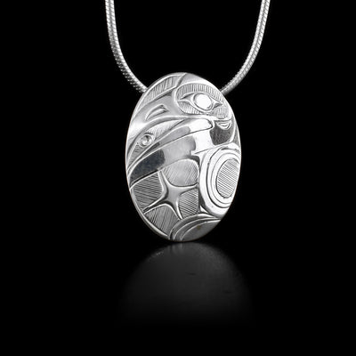 This sterling silver pendant is oval shaped and has carvings that depict the Hummingbird on it.