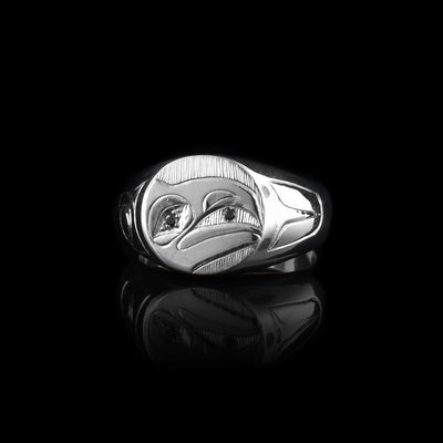 This Raven signet ring is made from sterling silver and has a thick, tapered band and an oval shaped signet. There is a depiction of the head of the Raven legend at a side profile carved into the signet. There are two black diamonds, one set into the eye and the other held in the beak.