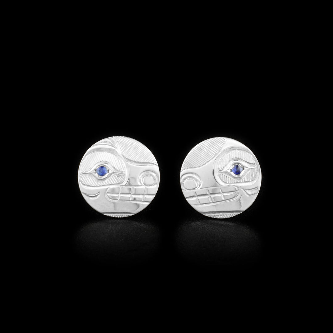These Bear earrings are made from sterling silver and sapphire gemstones and are circle shaped studs. There are depictions of the Bear carved into the surface of the earrings with sapphire embedded into the eyes of the Legends.