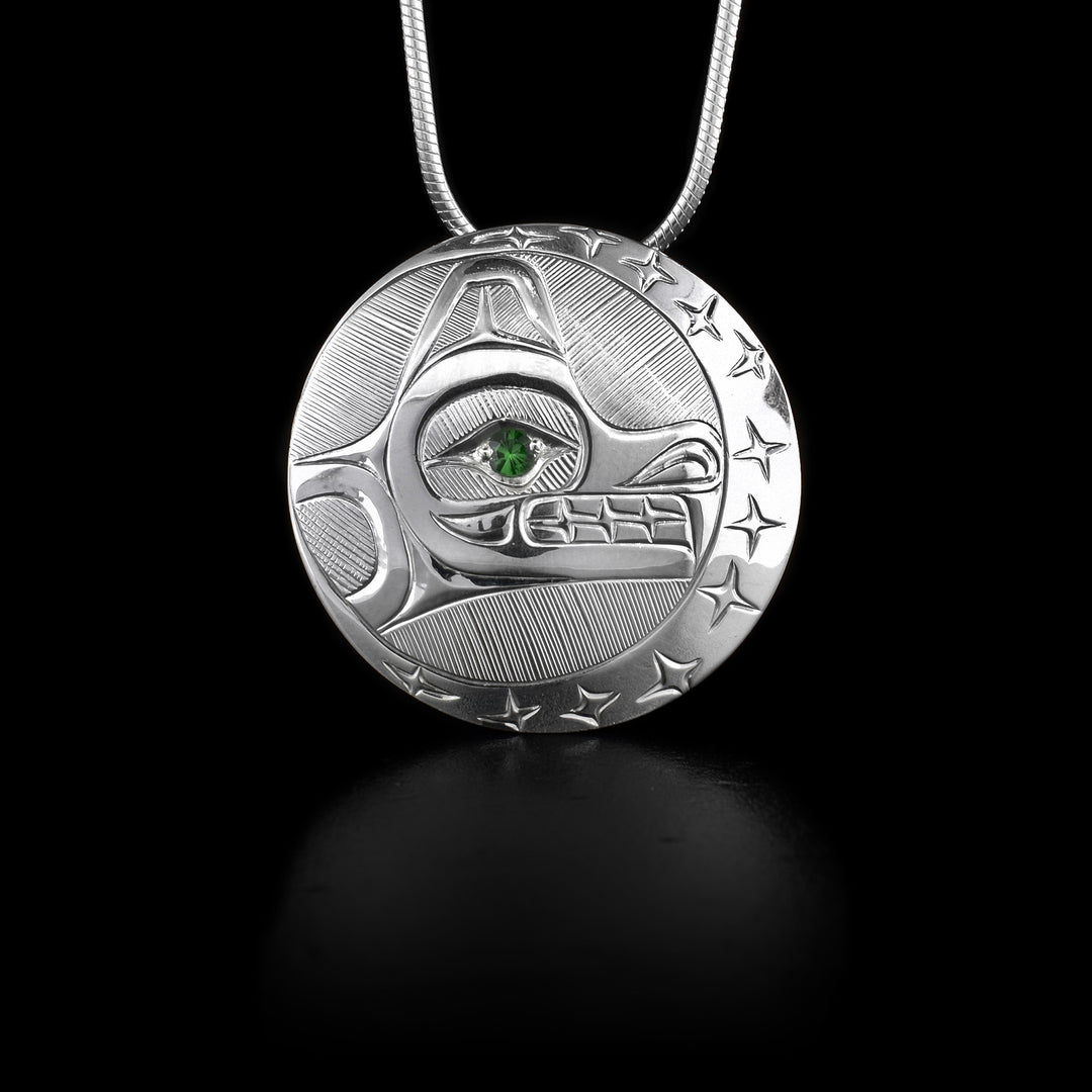 This Wolf pendant is made from sterling silver and is circle shaped with carvings that depict the Wolf and the Moon. There is a tsavorite gem embedded into the eye of the wolf.