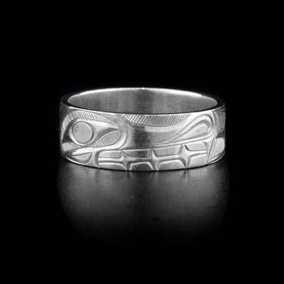 This sterling silver band ring is a single, flat band with carvings of the Wolf on it.