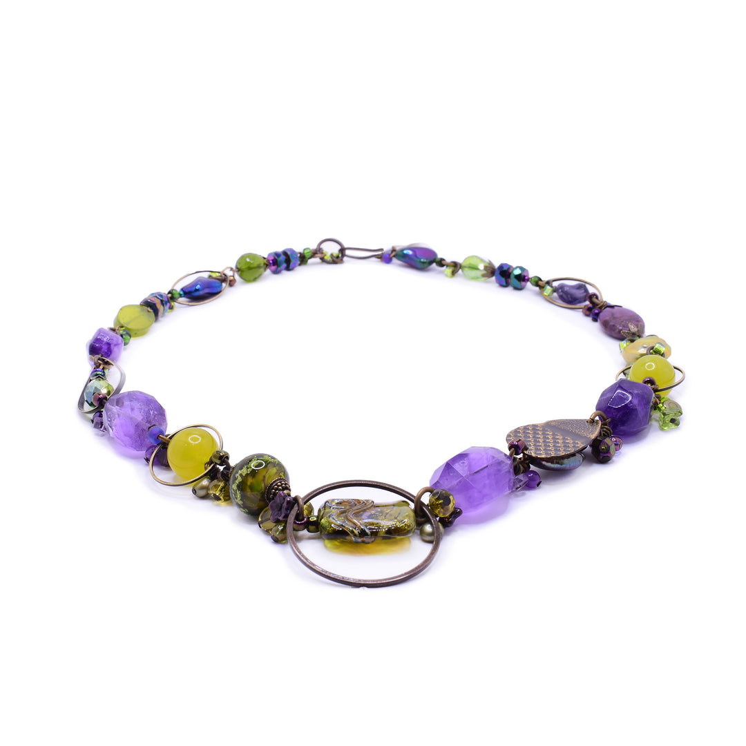 A stunning mixed gemstone necklace by artist Honica. Featuring BC Artist Glass, serpentine jade, amethyst, and Austrian crystals for a vibrant, artisanal look.