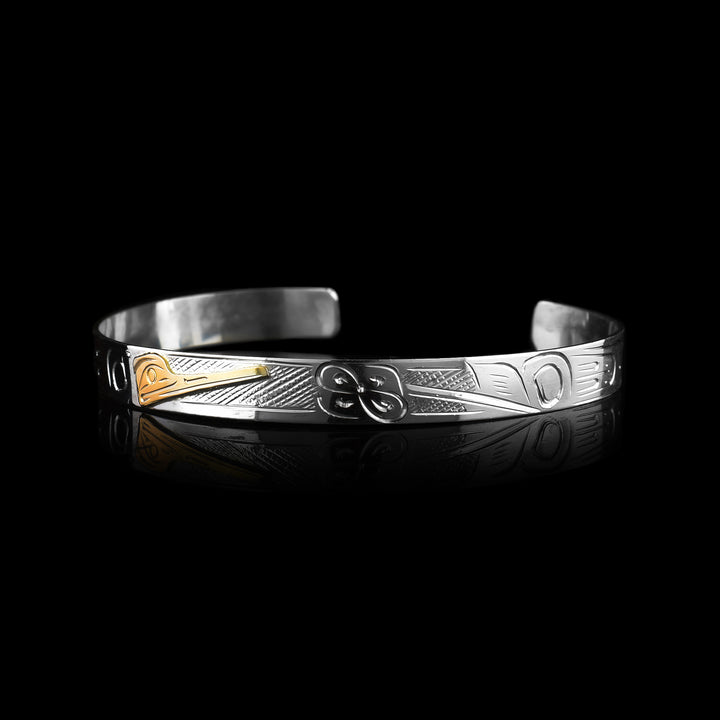 this Graham Henry Hummingbird cuff. Hand-carved by the Coast Salish artist, this sterling silver and 10k gold bracelet features a beautifully engraved Indigenous Hummingbird legend