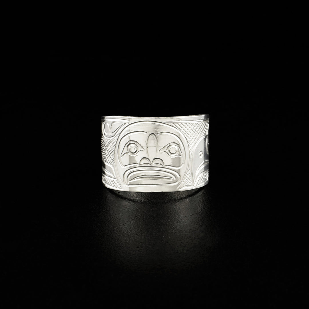Front view of ring with moon. Moon is done in lines and ovoids. Background is cross-hatching.