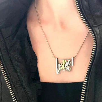 The photo shows the pendant on the neck of a model. It is a close up shot.