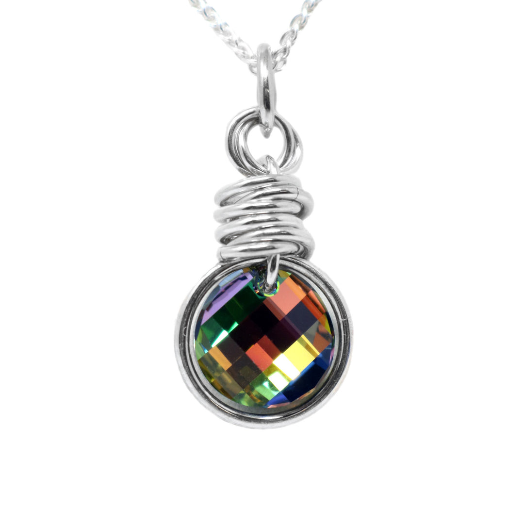This vitrail medium Swarovski crystal pendant has a circled shaped crystal with a large, sterling silver hoop fitted around it. There are several, sterling silver hoop stacked above the crystal with another hoop connecting the piece to the jump ring. The Swarovski crystal has colors including yellow, red, blue, green and orange.