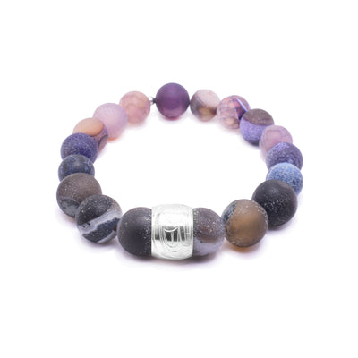 This beaded agate bracelet is made up of multi colored agate beads. The beads are sphere shaped, small and there is a sterling silver spirit bead in the front of it. There is a depiction of the Orca carved into the spirit bead.