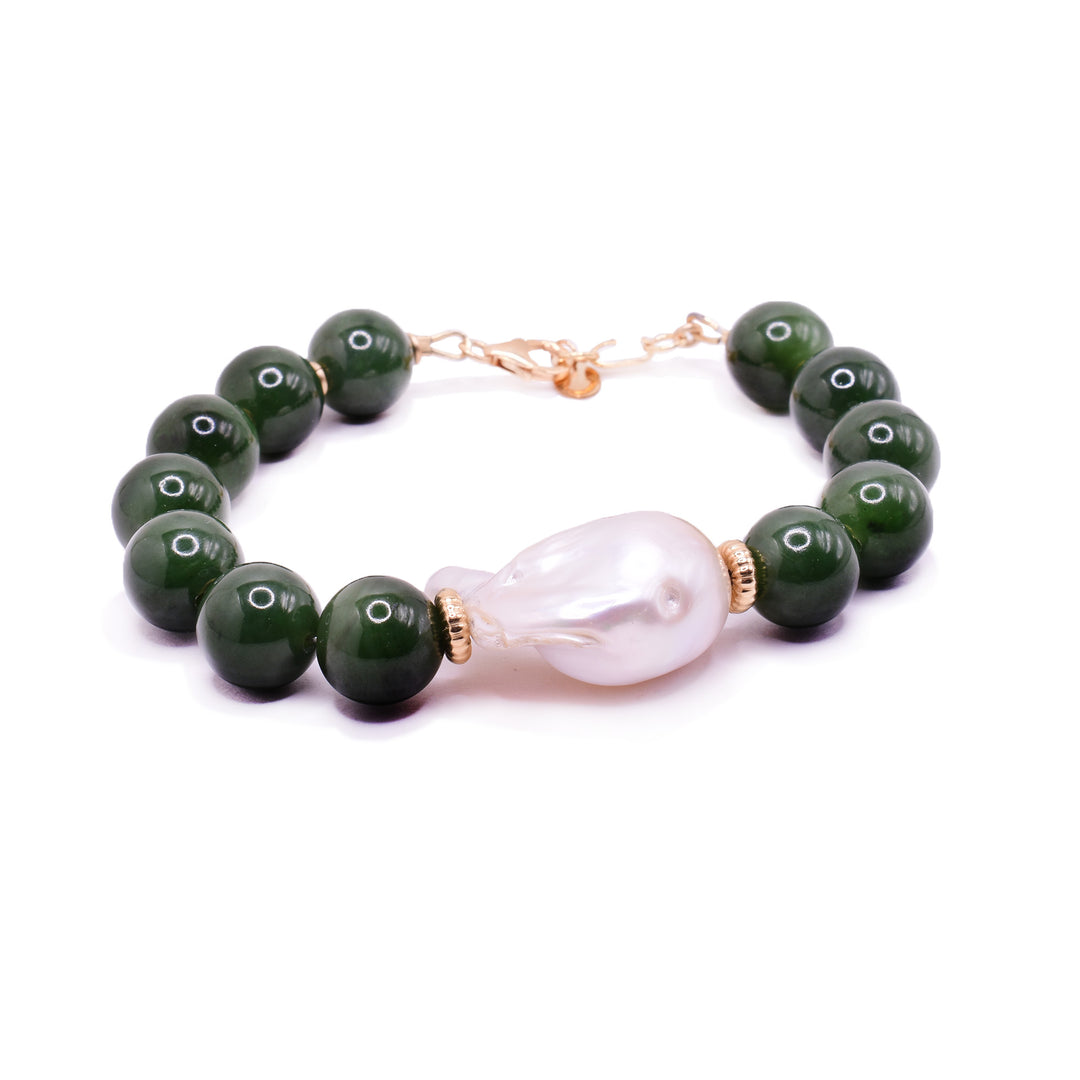 This baroque pearl bracelet has sphere shaped jade beads and a large baroque pearl featured in the center of it. The piece has a 14K gold filled chain and a few beads on both sides of the pearl.