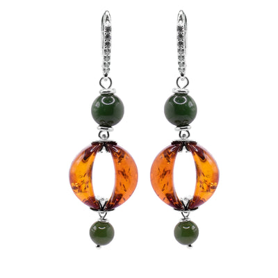 These amber earrings have circle shaped amber hangs with a cutout in the middle. The amber is framed by a jade bead above and below the piece and these long dangling earrings are held together by sterling silver hoops. There are several, cubic zirconia gems displayed in the hooks.